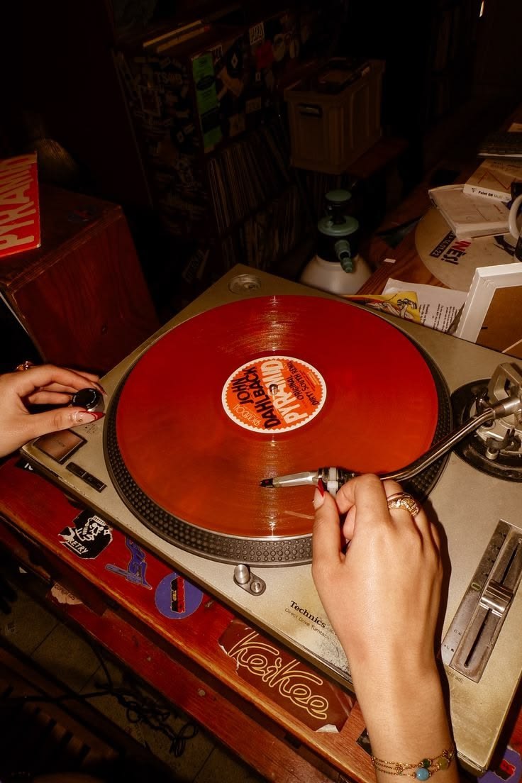Analog turntable spinning a red vinyl record